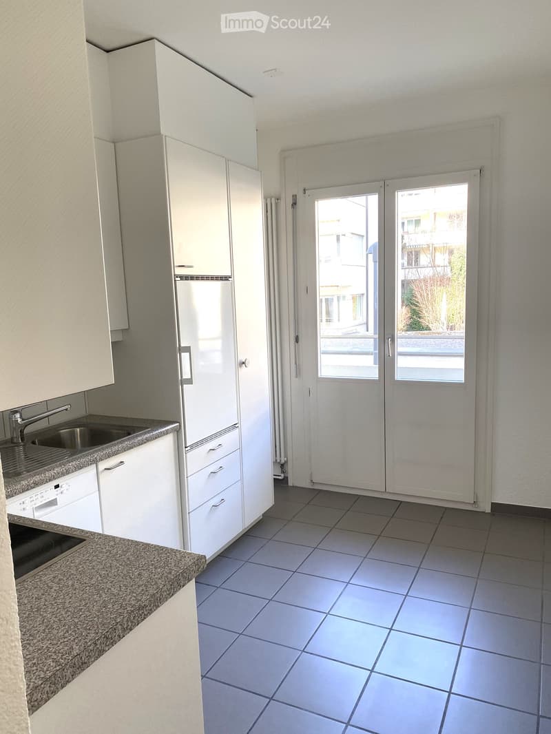 kitchen, white cabinets, granite countertop, stainless steel sink, dishwasher, white appliances, tiled floor, glass doors to balcony