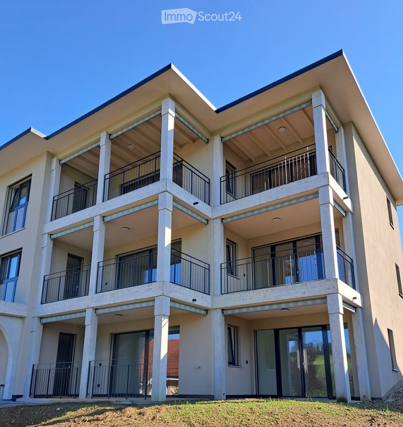 Modern two-story building with multiple balconies, large windows, and a clean, contemporary design.
