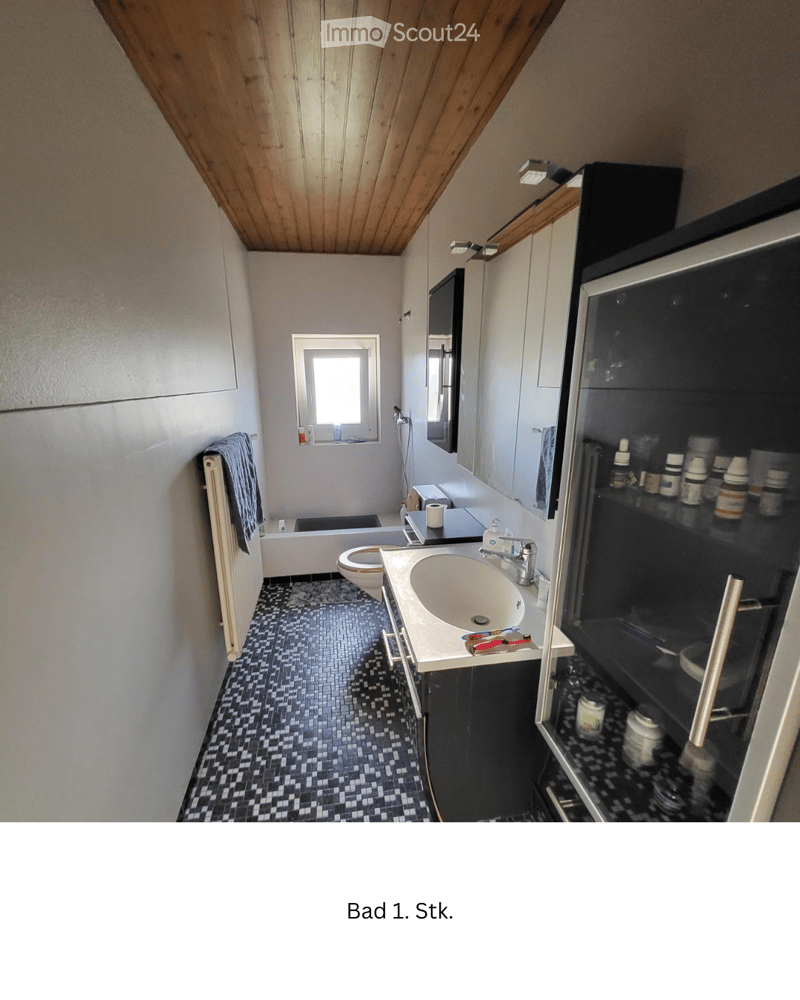 Bathroom with a sink, toilet, bathtub, mirror, and cabinet. Features a black and white tiled floor and a wooden slanted ceiling.
