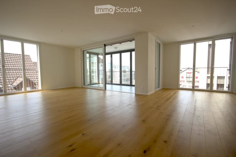 Empty room with hardwood floors, sliding glass doors, and city views