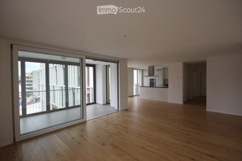 Open floor plan with sliding glass doors leading to a balcony, modern minimalist interior design, wooden floor, high ceiling