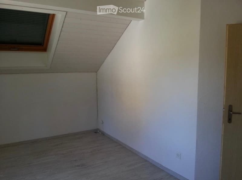 Empty room with wooden flooring, white walls, and a skylight window. No furniture or equipment present.