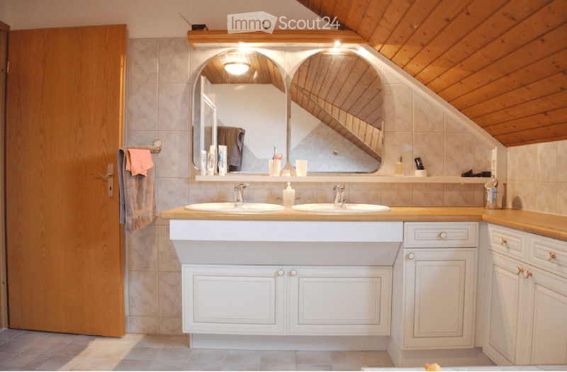 Modern bathroom with double sink vanity, large mirrored cabinet, and built-in storage cabinets.