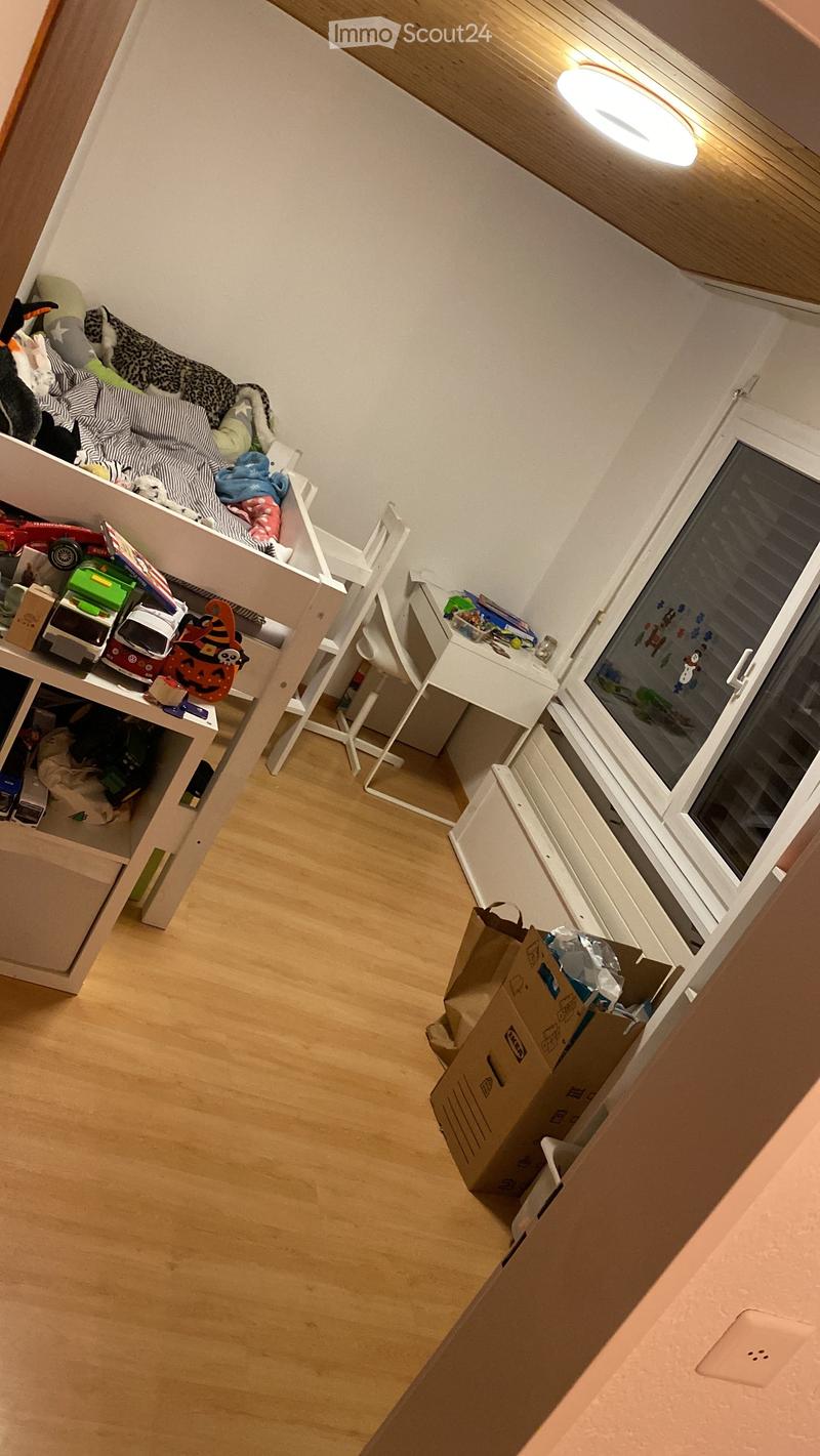 Empty room with wooden flooring, white walls, and a window with blinds. There are no visible furniture or items.