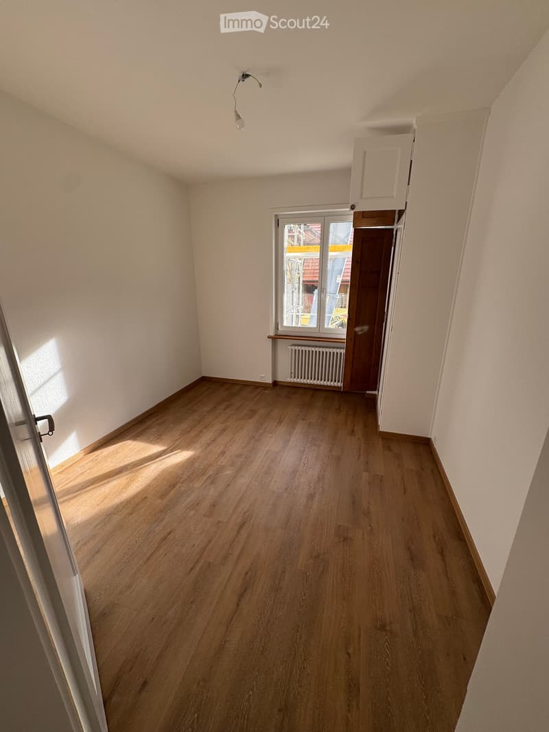 empty room, wooden floors, white walls, window with balcony, radiator, overhead light