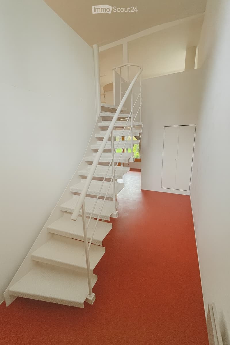 modern staircase with white steps, white railings, red floor