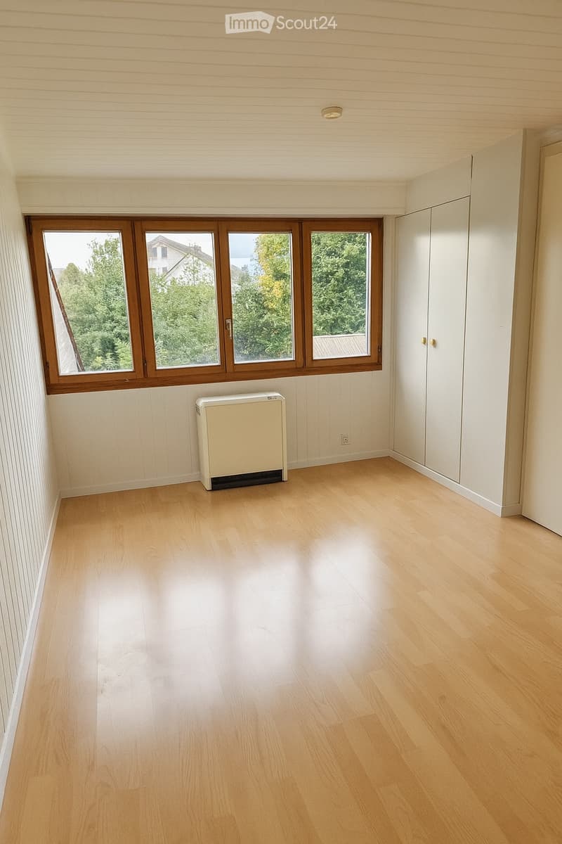 empty room, white walls, wooden floor, window with view of outside, radiator, wardrobes