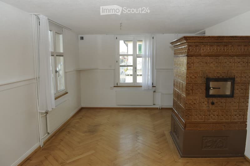 empty room, wooden floor, fireplace, 2 windows, white walls, radiator
