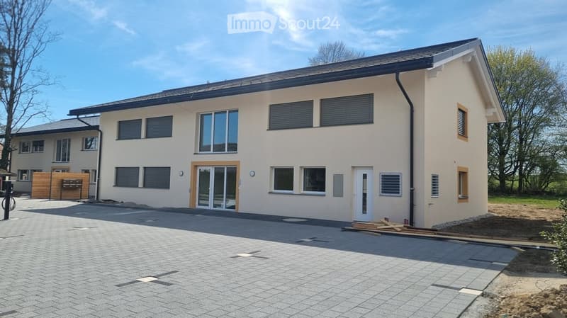 2 story house, beige exterior, large windows, black roof, driveway, wooden fence, construction site
