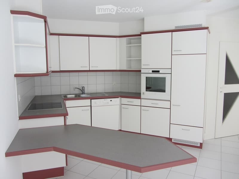 Modern kitchen with white cabinets, stainless steel appliances, and a grey countertop.