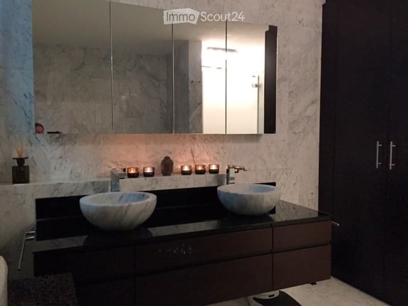 Modern bathroom with a double sink vanity, large mirror, and dark wood cabinets.