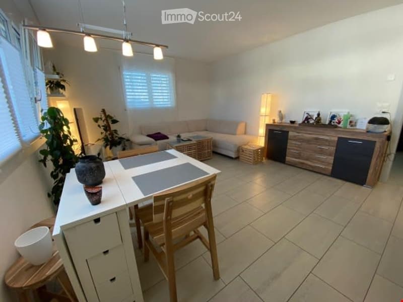 white tile floor, light fixtures, dining table, couch, wooden side table, wooden cabinet, lamp, plants