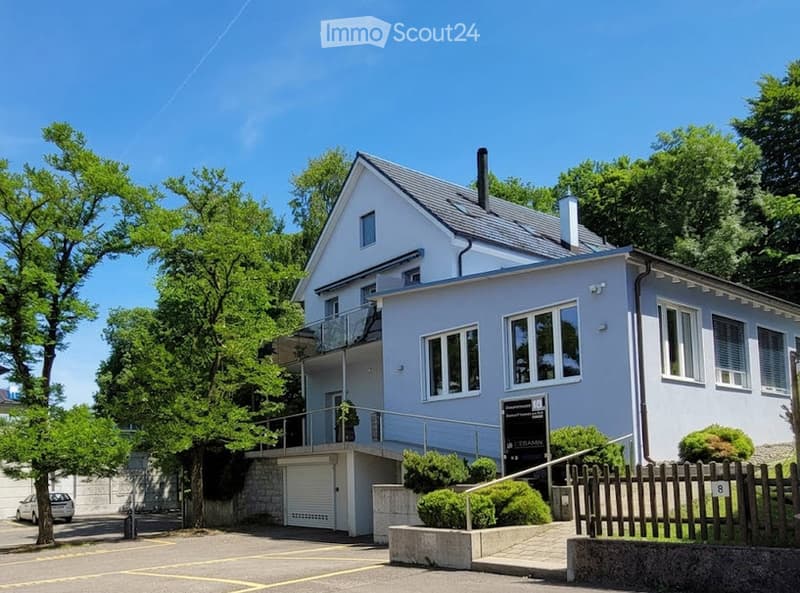 Two-story house with light blue exterior, white trim, garage, and balcony on the upper level.