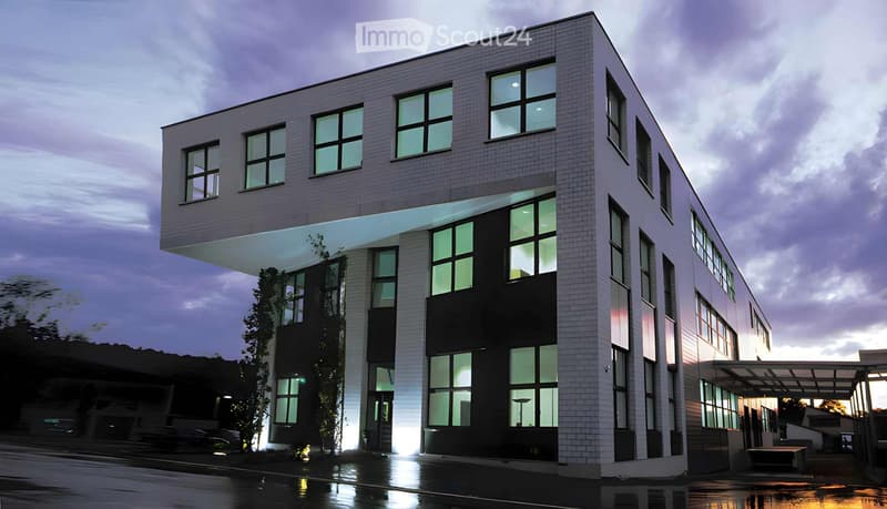 Modern multi-story building with a combination of white brick and dark paneling, large windows, and a sleek design.