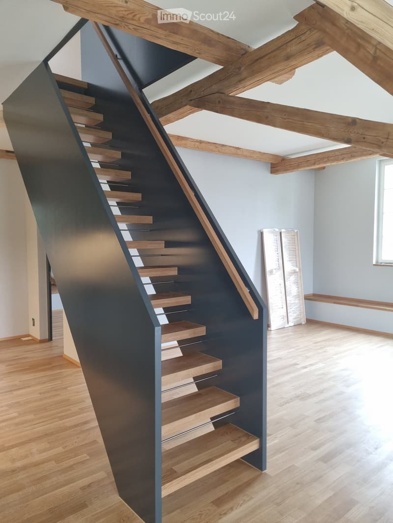 modern design staircase, black metal railing, wooden steps, wooden ceiling beams