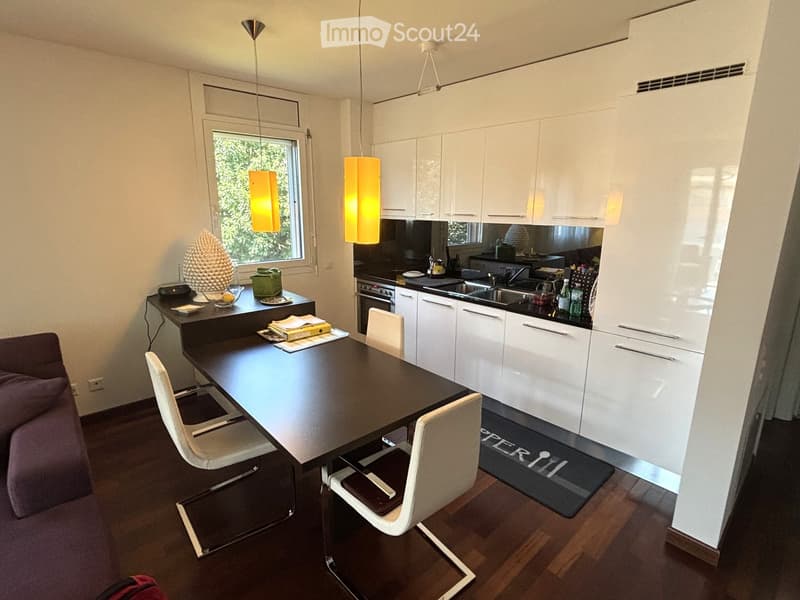 modern white kitchen with stainless steel appliances, black dining table, 4 white dining chairs, dark hardwood floor