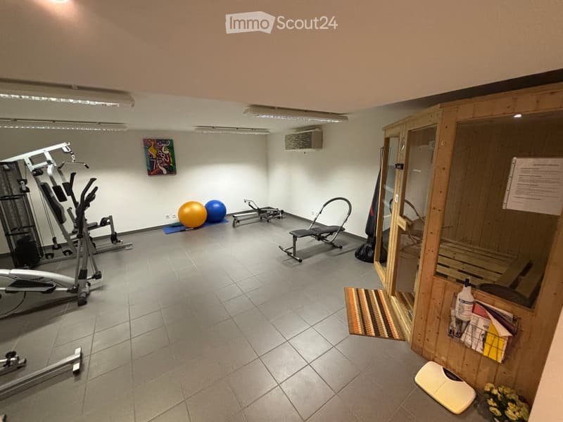 well-equipped gym with multiple exercise machines, yoga mats, medicine balls, a bench, and a wooden sauna
