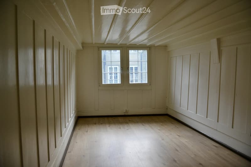 empty room, wooden floor, wooden paneled walls, two windows