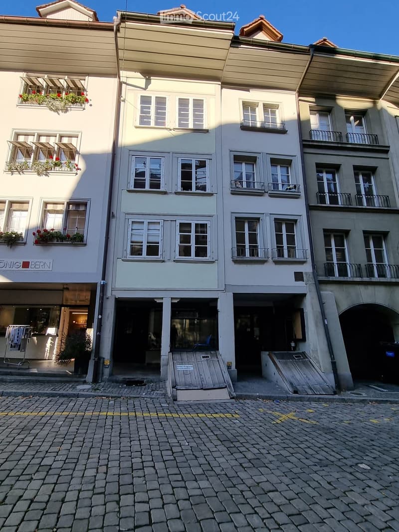 4 story building with brick exterior, awnings, flower boxes, balcony, open garage