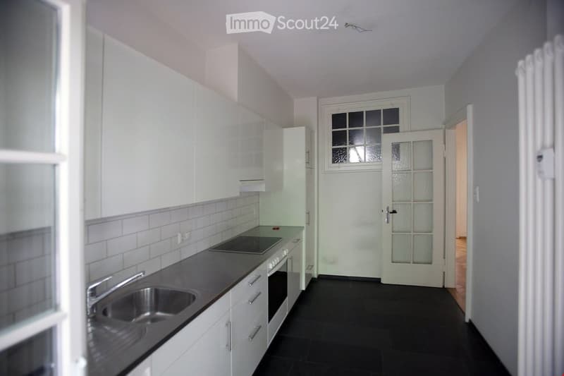 white cabinets, tiled backsplash, gray tiled floor, sink, stove, oven, glass door, window