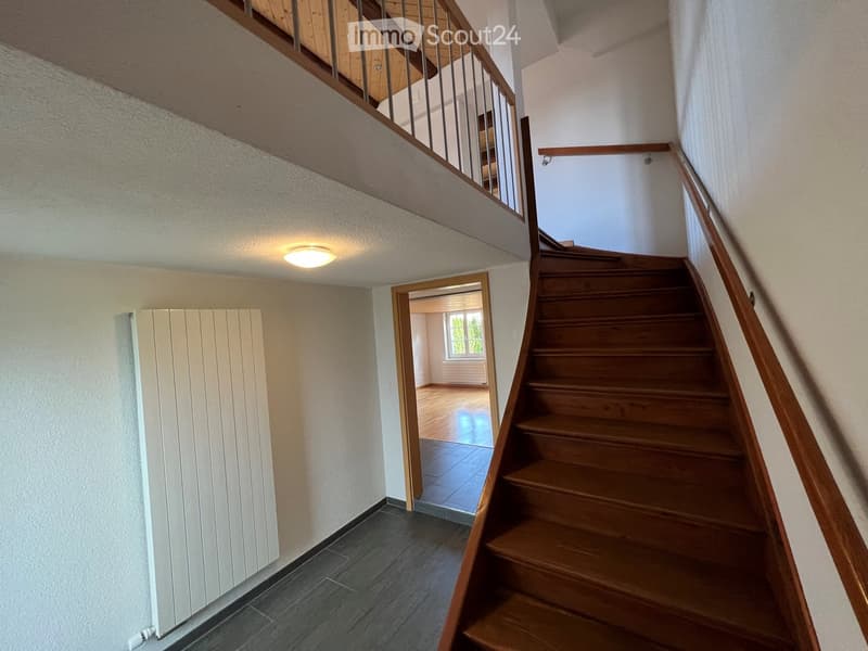 wooden staircase, white walls, wooden floor, white radiator, balcony