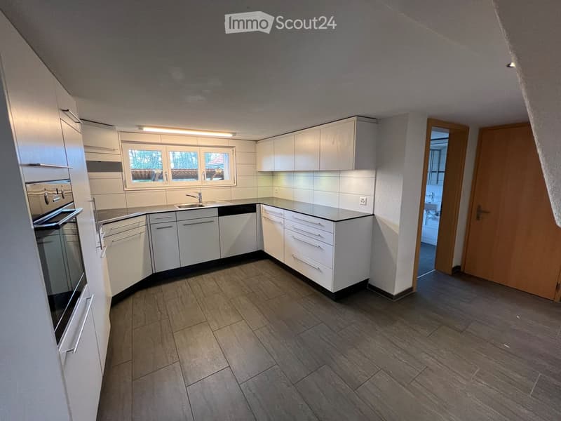 modern kitchen with white cabinets, black countertops, built-in oven, dishwasher, sink, and faucet