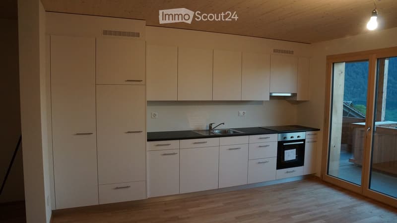 modern kitchen with white cabinets, black countertops, stainless steel sink, oven, and dishwasher