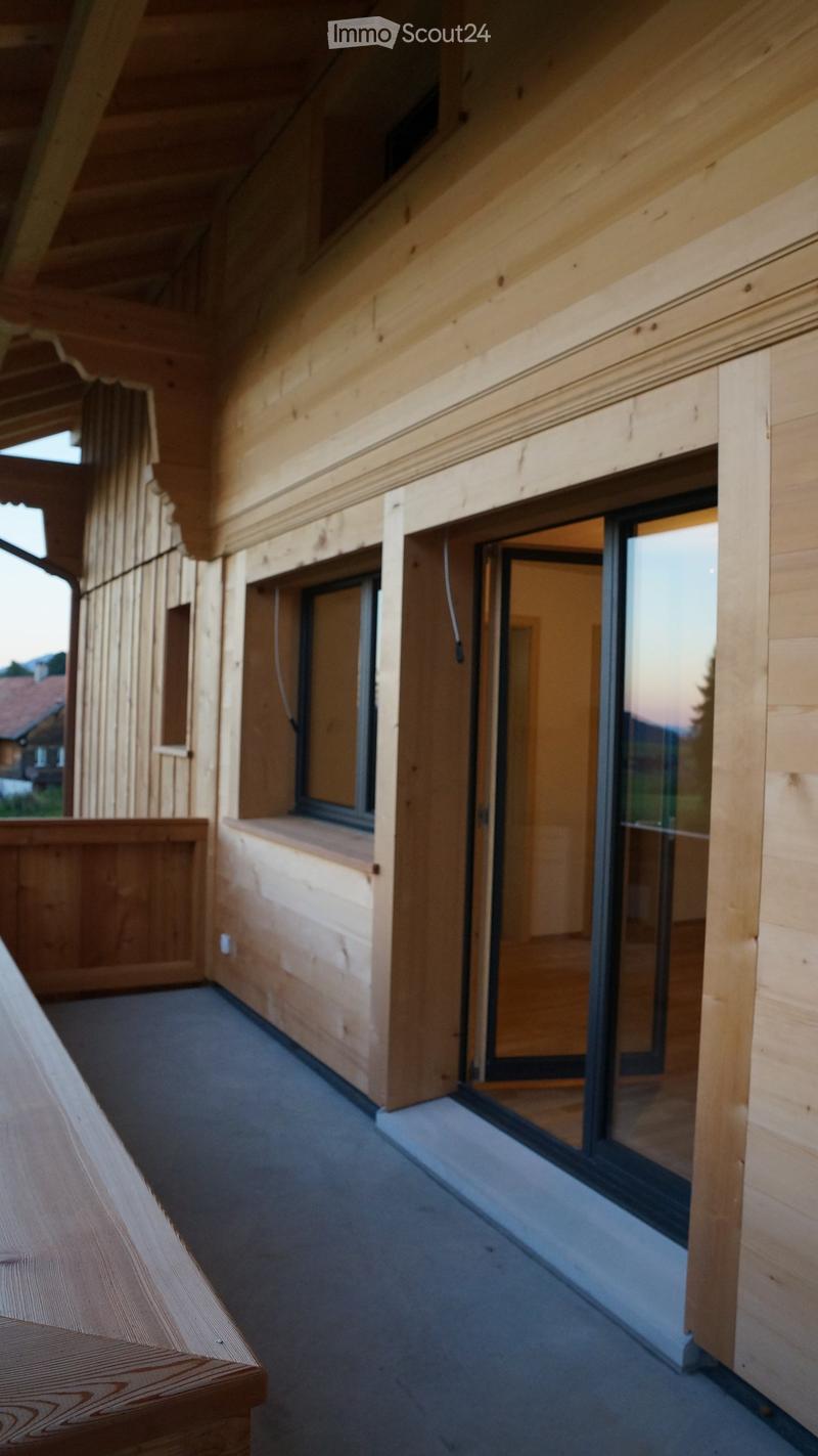 wooden walls, balcony, sliding glass doors, wooden bench, gray floor