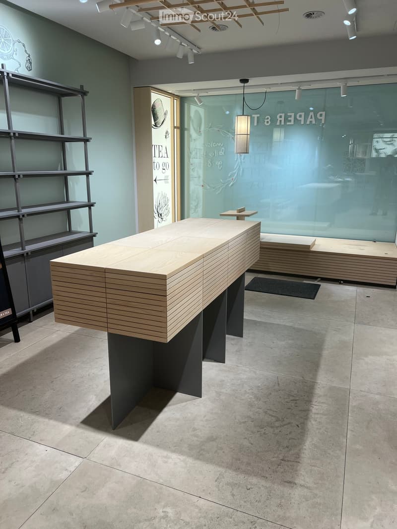 modern wooden desk, gray metal shelves, tiled floor, large glass wall, wooden bench, black rug