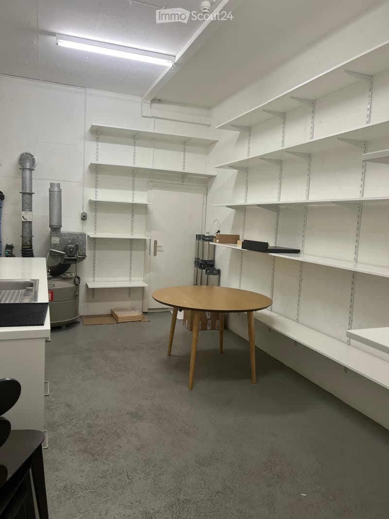 empty room with white walls, wooden table, white shelves, white ceiling, white floor, white kitchen counter, black chairs