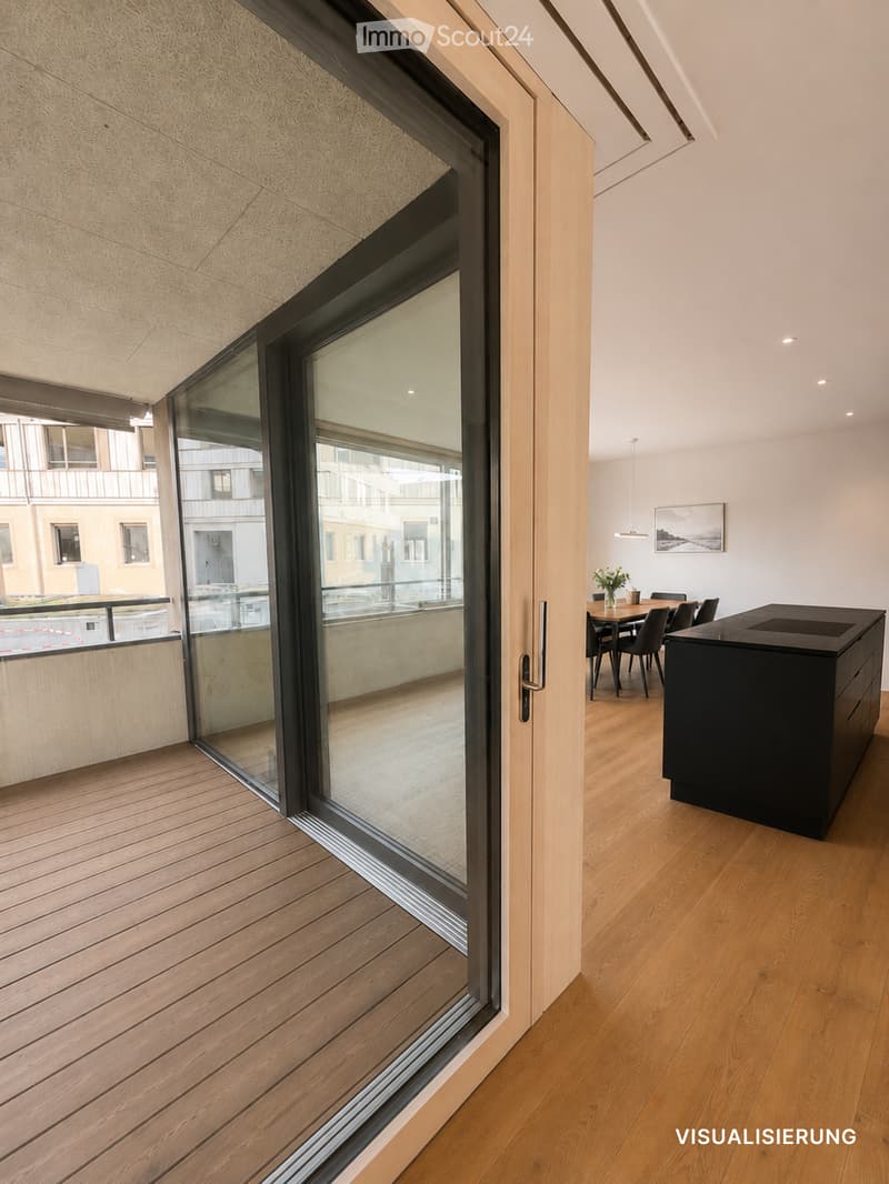 Modern interior with wooden flooring, large glass sliding doors leading to a balcony, kitchen island, dining table with chairs, and a flower vase on the table.