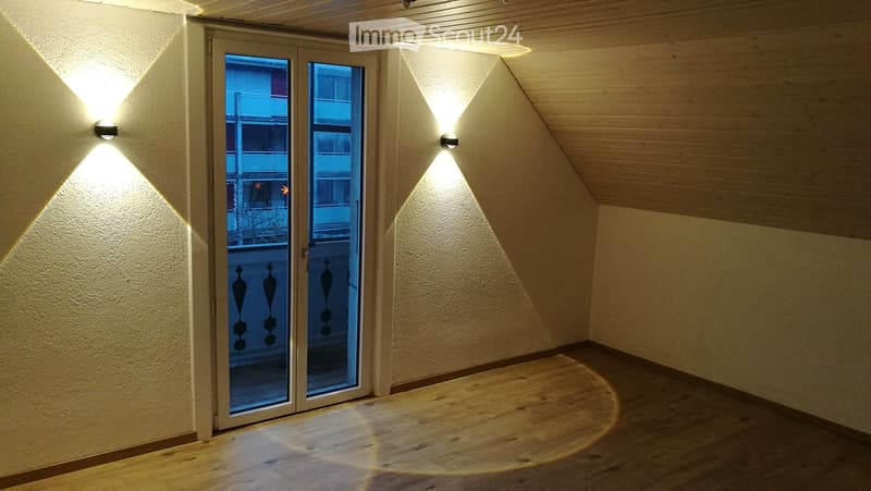 wooden floor, white walls, large sliding doors, wall mounted lights, balcony