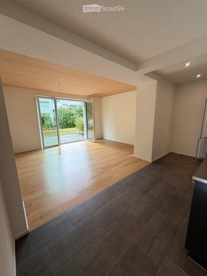 Empty room with wooden flooring, large sliding glass door leading to a balcony or terrace, and white walls.