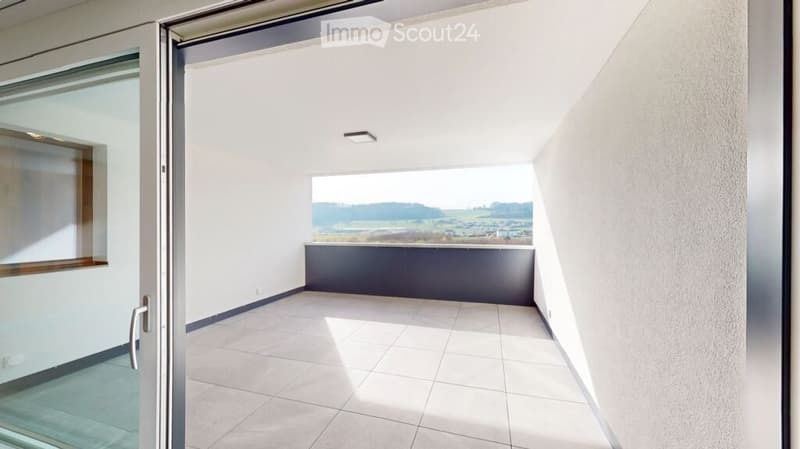 Modern balcony with tiled floor, white walls, and a panoramic view of the countryside.