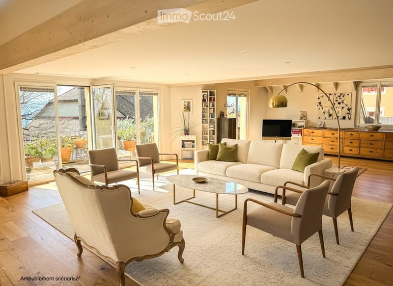 Modern living room with large windows, white sofa, coffee table, armchairs, TV, floor lamp, and bookshelf.