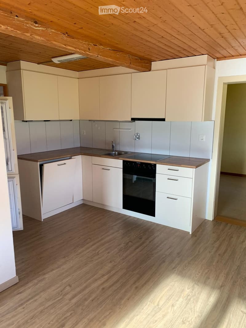 Modern kitchen with light-colored cabinets, wooden countertops, and a stainless steel sink and oven.