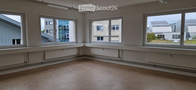 Empty room with large windows, white walls, and a smooth concrete floor. No furniture or equipment is present.