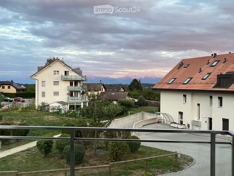 Residential area with multiple houses, a balcony, and a scenic mountain view in the background.