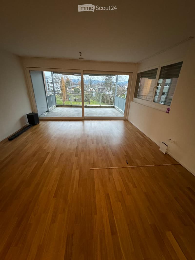 wooden floor, sliding doors to balcony, white walls