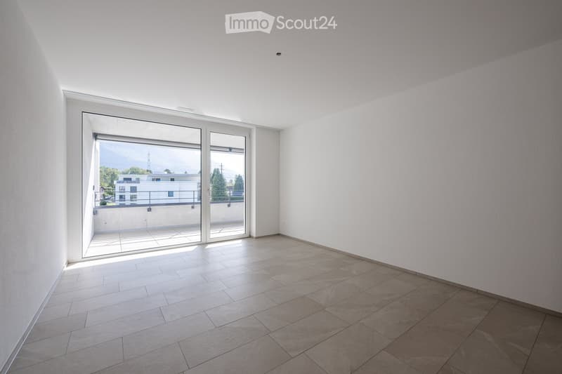 Empty room with white walls, tiled floor, and large sliding glass doors leading to a balcony.