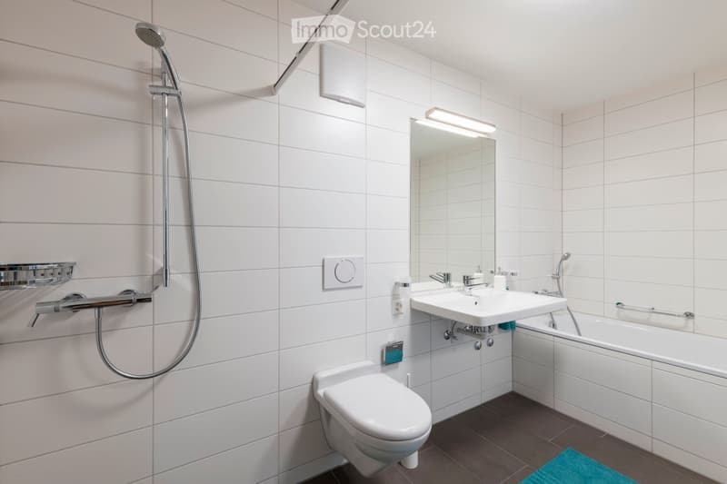 white tiles, shower with shower head, bathtub, toilet, sink, mirror, under sink cabinet