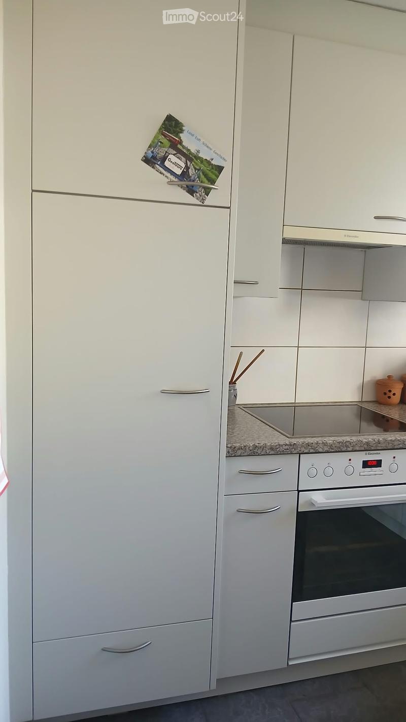 Modern kitchen with white cabinets, stainless steel appliances, and a granite countertop.