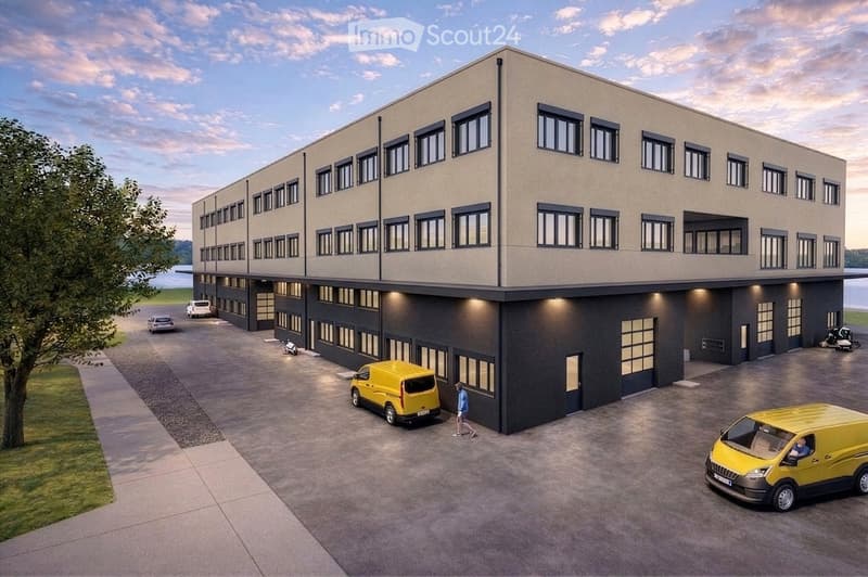 A modern two-story building with a flat roof, large windows, and a spacious parking area with several vans and a person walking.