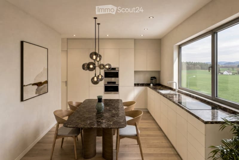Modern kitchen with light-colored cabinets, marble countertops, a central dining table with chairs, and a pendant light fixture. Large windows offer a scenic view of the countryside.