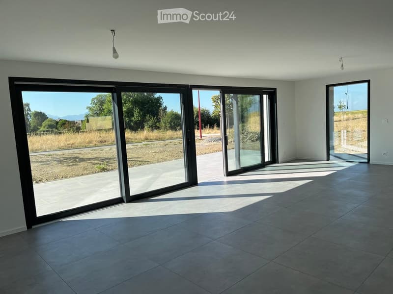 Empty room with large sliding glass doors, tiled floor, and natural light. No furniture or equipment visible.