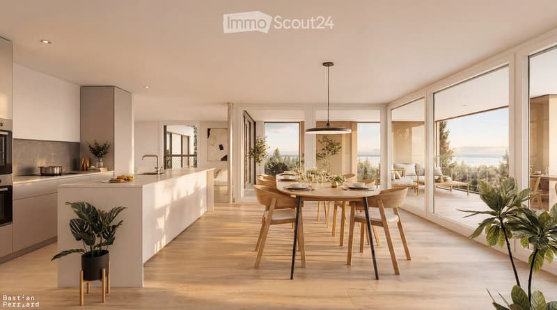 Open-plan kitchen and dining area with light wood flooring, white cabinetry, a central island, and a round dining table with six chairs. Large windows offer a scenic view.