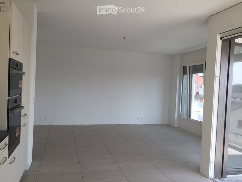 Empty room with tiled floor, white walls, and large windows. No furniture or equipment present.