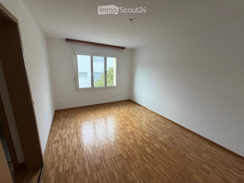 Empty room with wooden flooring, white walls, and a window with blinds. No furniture or equipment is present.