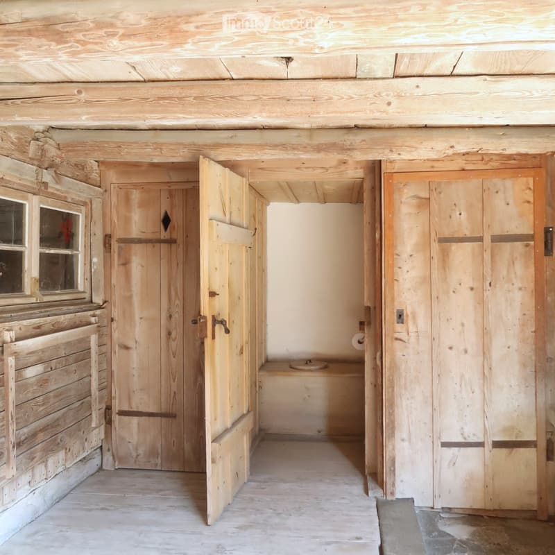 Bathroom with wooden interior, a toilet, wooden windows and doors.