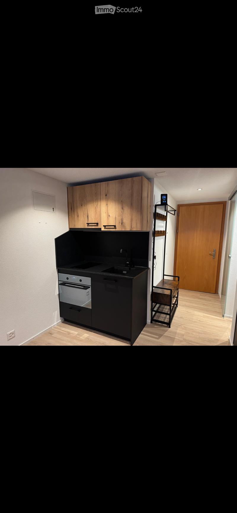 Small kitchen, modern design, black countertop, wooden cabinets, oven, sink, white walls